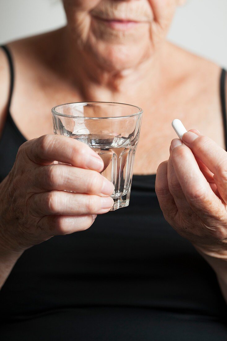 Elderly woman taking a pill