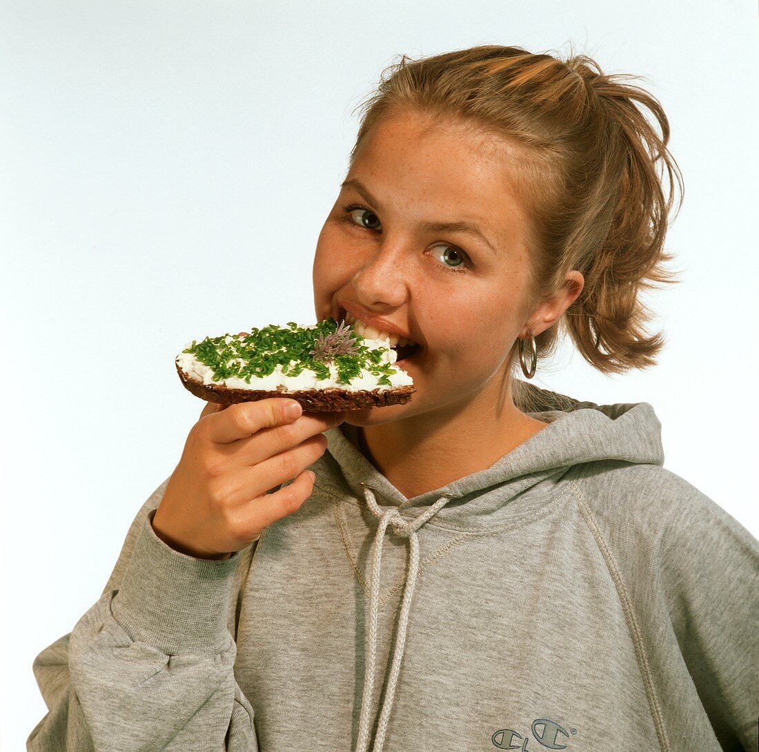 Woman Eating Bread with Herbed Cream Cheese