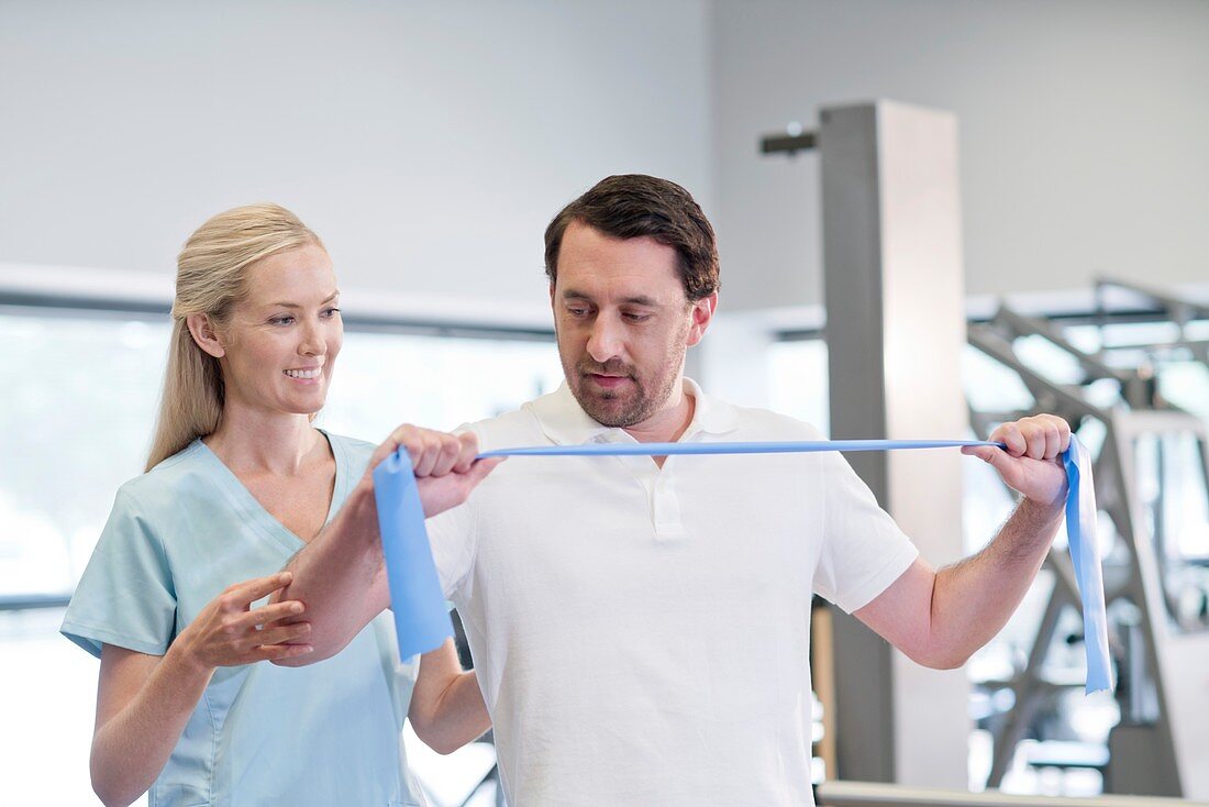 Nurse showing man how to use resistance band