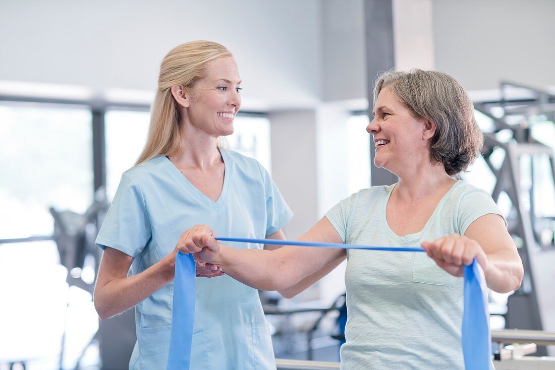 Nurse showing woman how to use resistance band