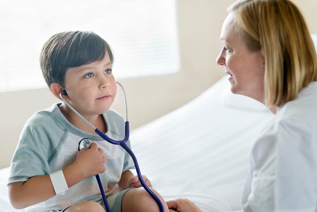 Boy wearing stethoscope with nurse