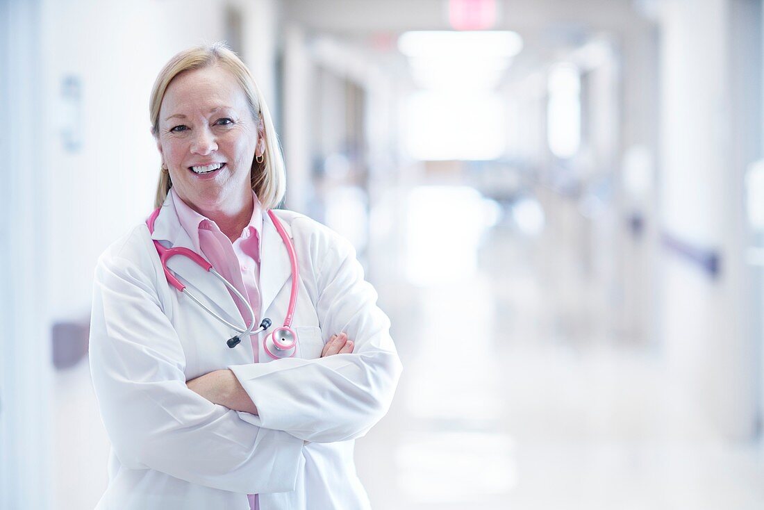 Mature nurse smiling with arms folded