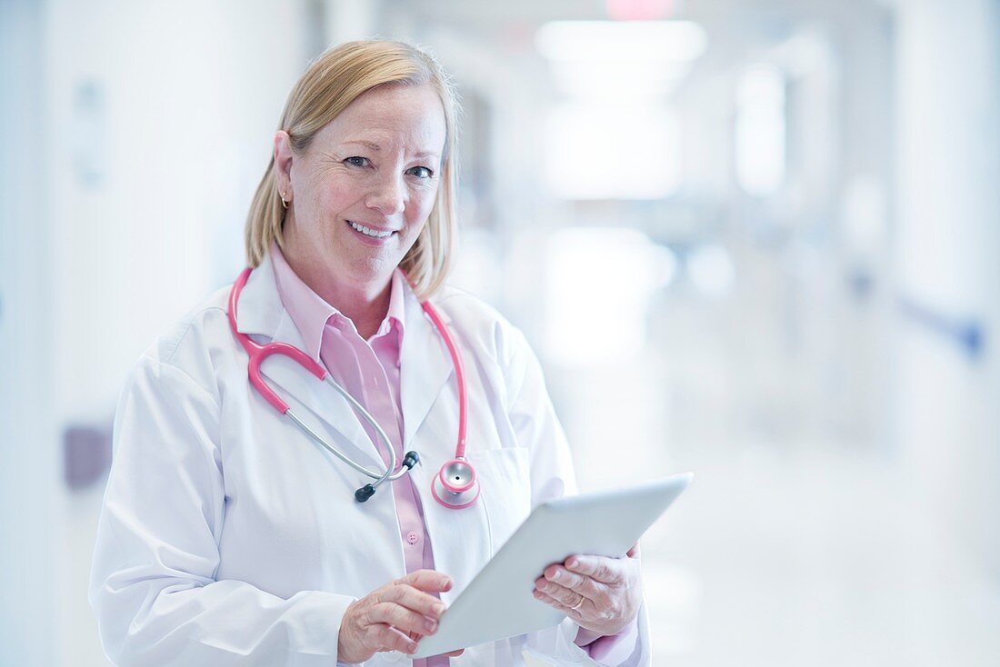 Mature nurse using digital tablet in hospital