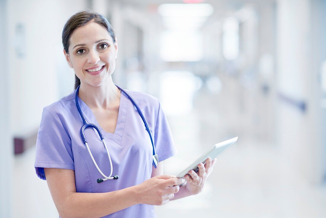 Nurse wearing purple uniform using digital tablet