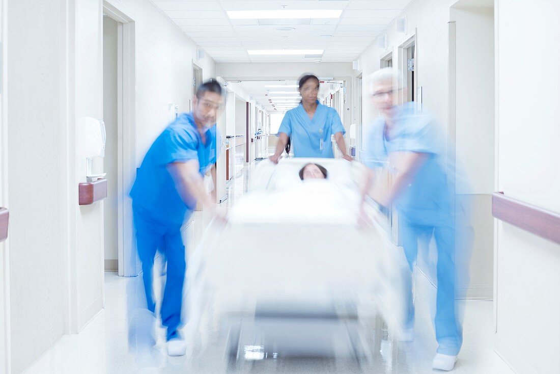 Medical team pushing patient on bed