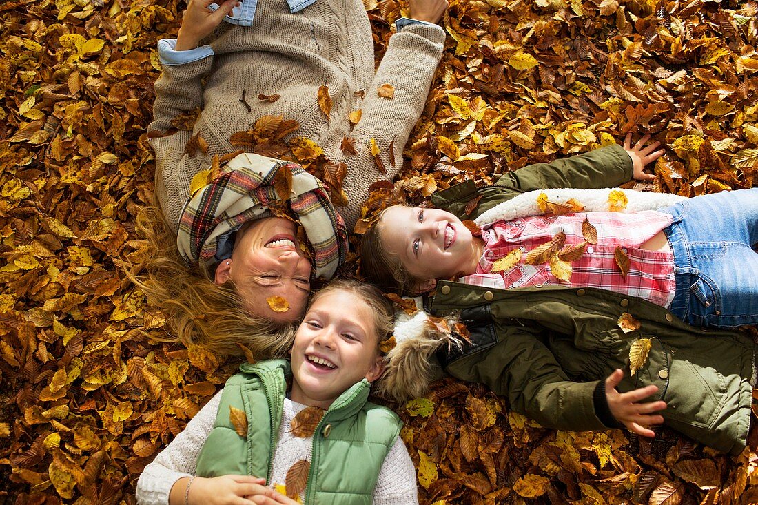 Family lying down on Autumn leaves