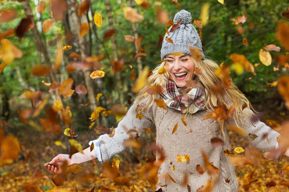 Woman playing in Autumn leaves