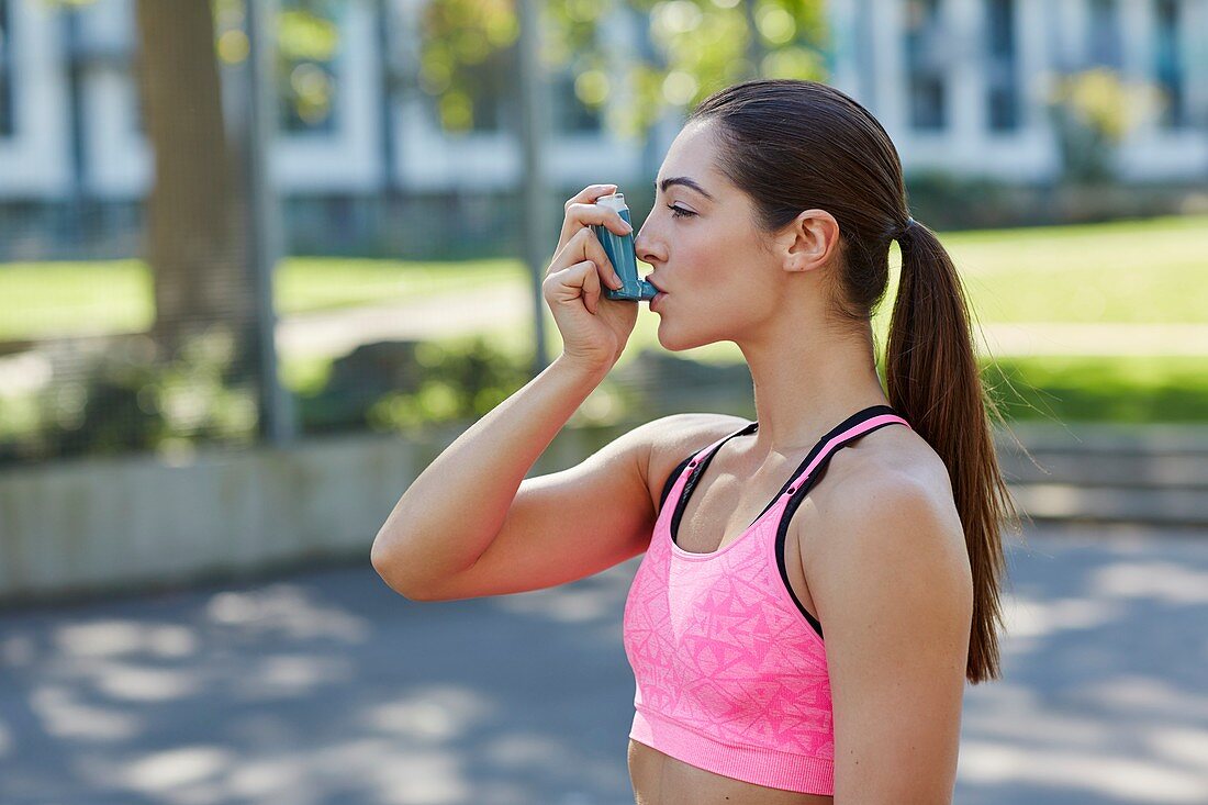 Young woman using inhaler