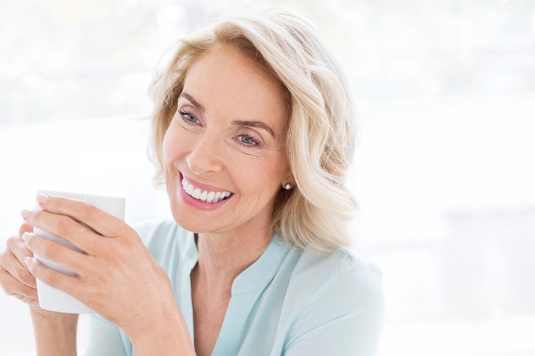 Mature woman smiling with cup of tea
