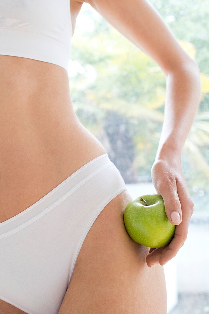 Woman wearing white underwear holding apple