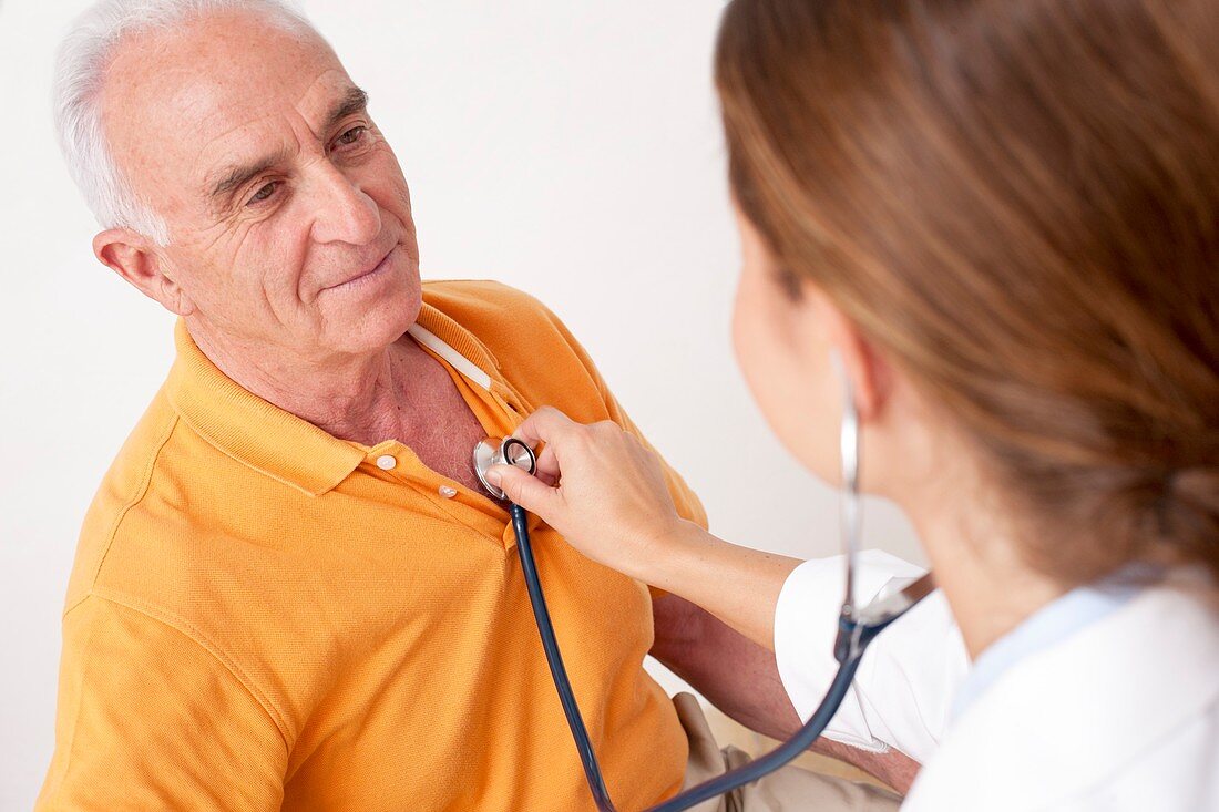 Doctor listening to senior male patient's chest