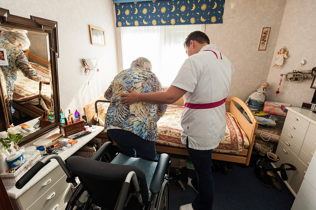 Nurse aiding an elderly woman