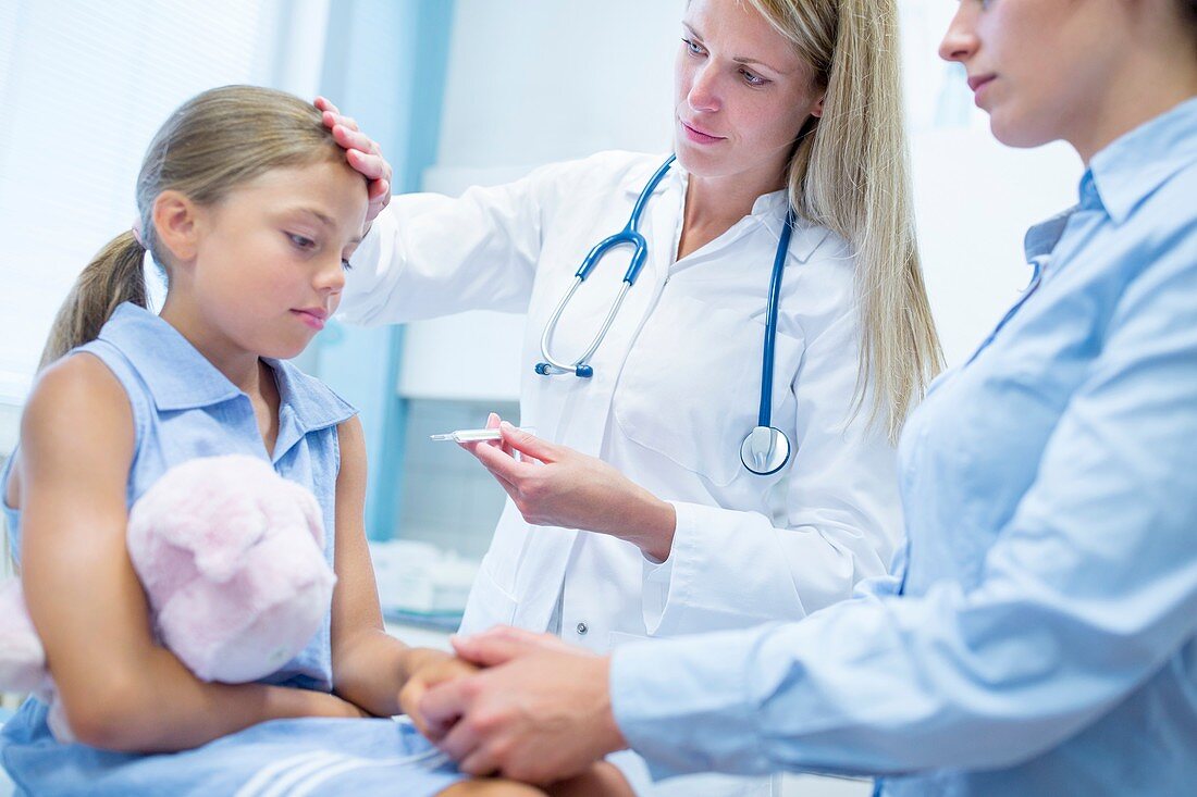 Doctor taking girl's temperature