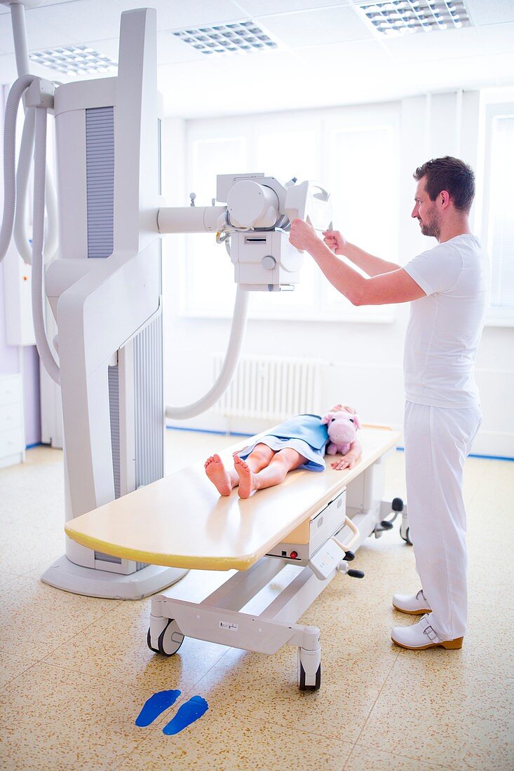 Doctor preparing girl for x-ray in hospital