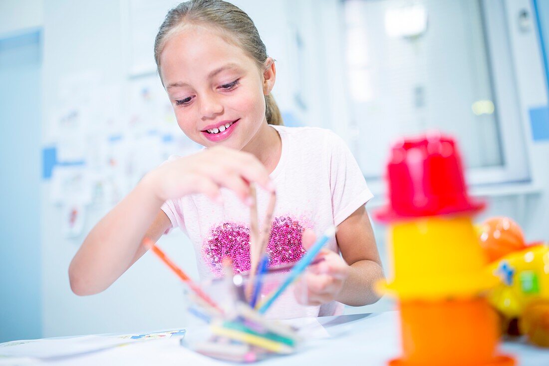 Girl with colouring pencils, smiling