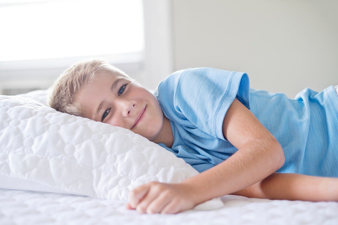 Young boy lying with head on pillow
