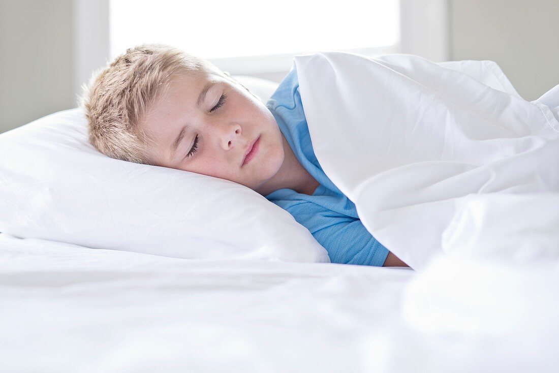 Young boy asleep with head on pillow