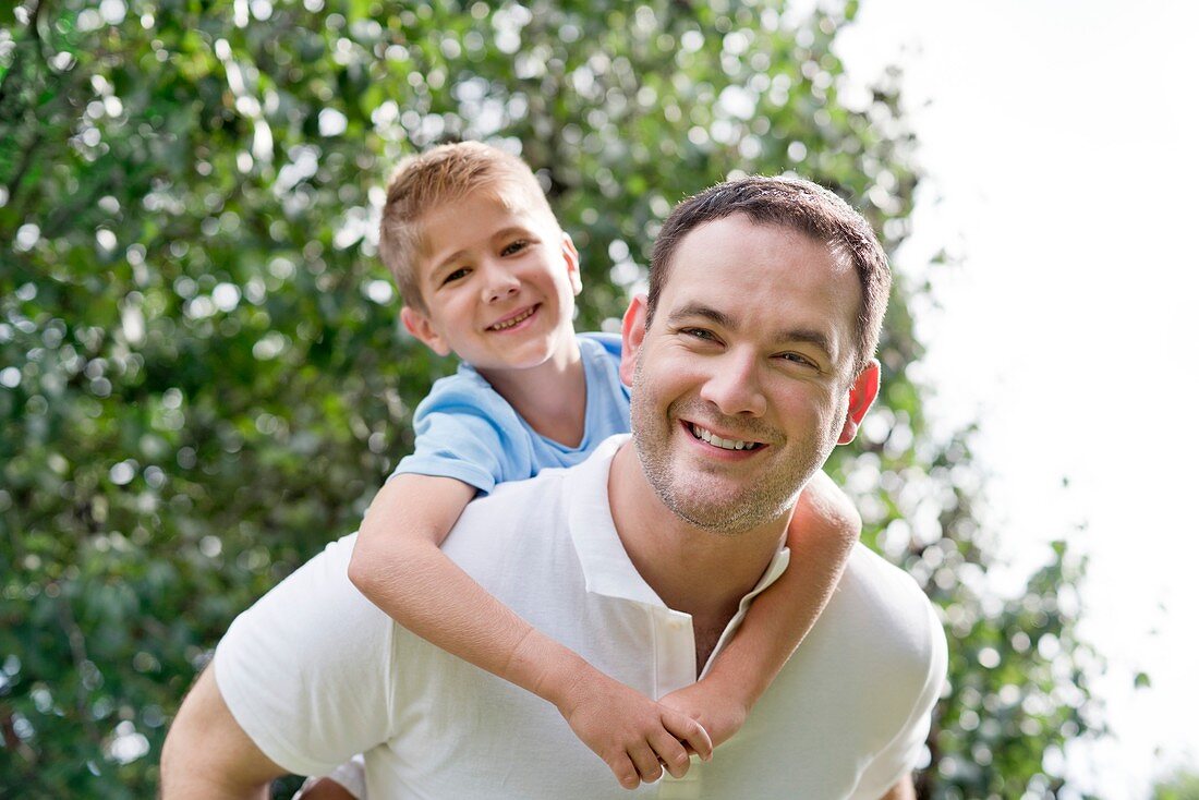 Father giving son piggy back