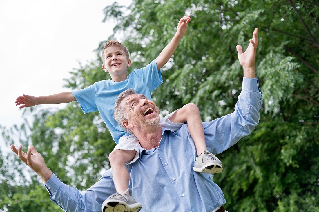 Grandfather carrying grandson on shoulders