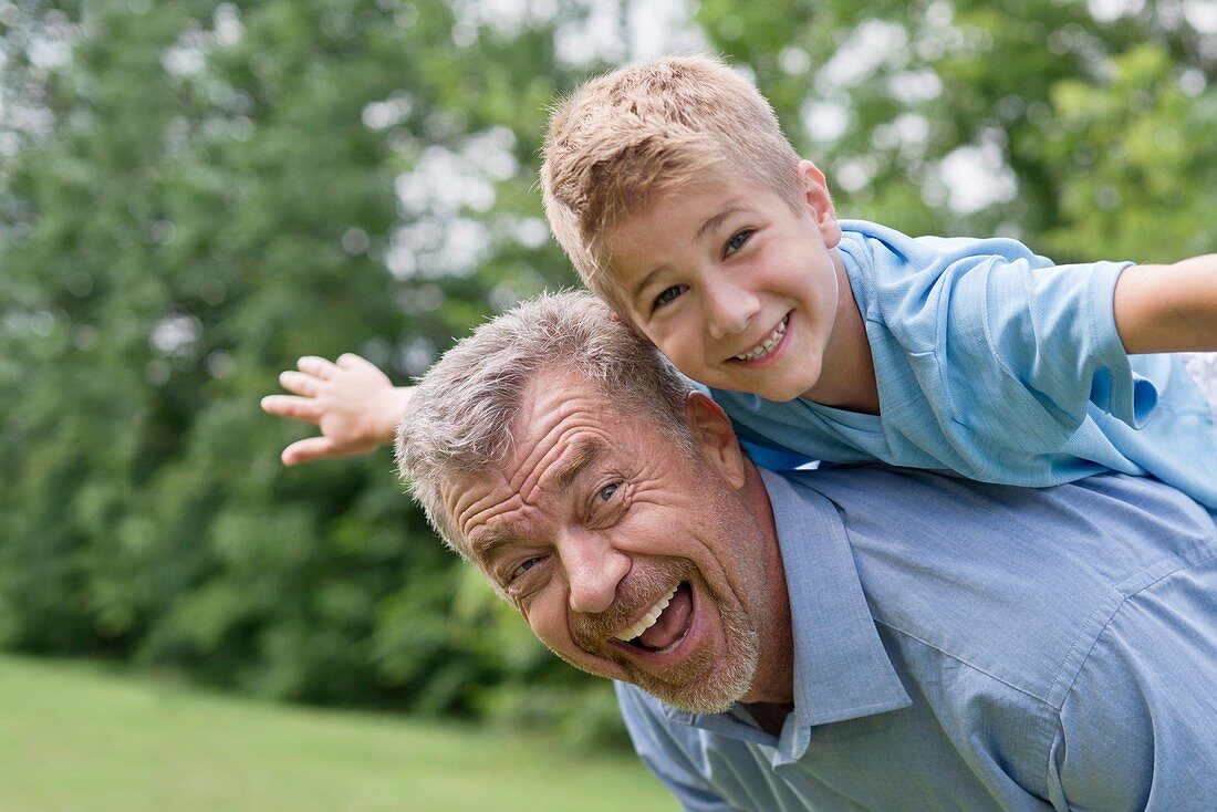 Grandfather giving grandson a piggy back