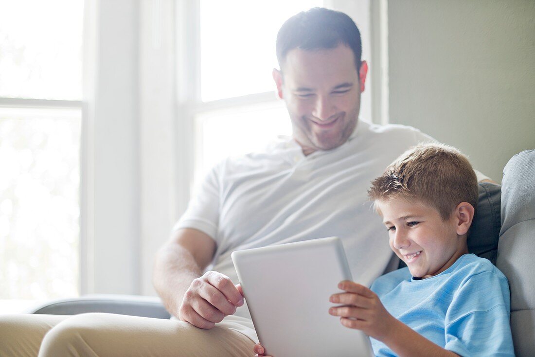 Boy using tablet with his father