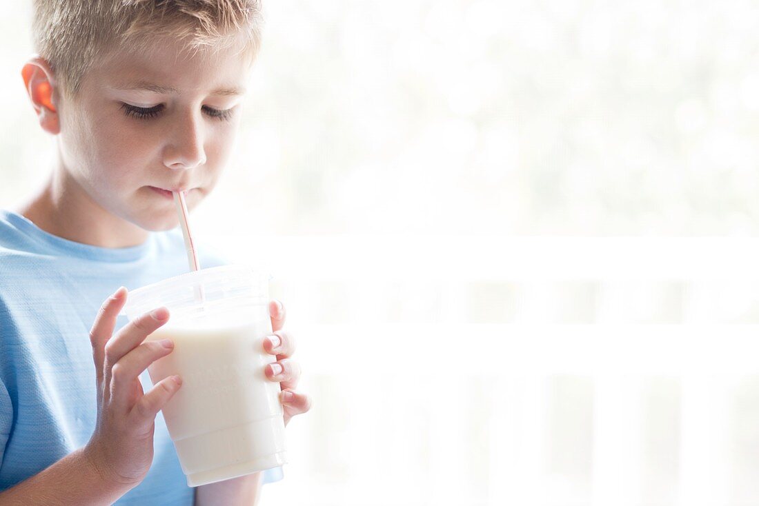 Boy drinking milk through a straw