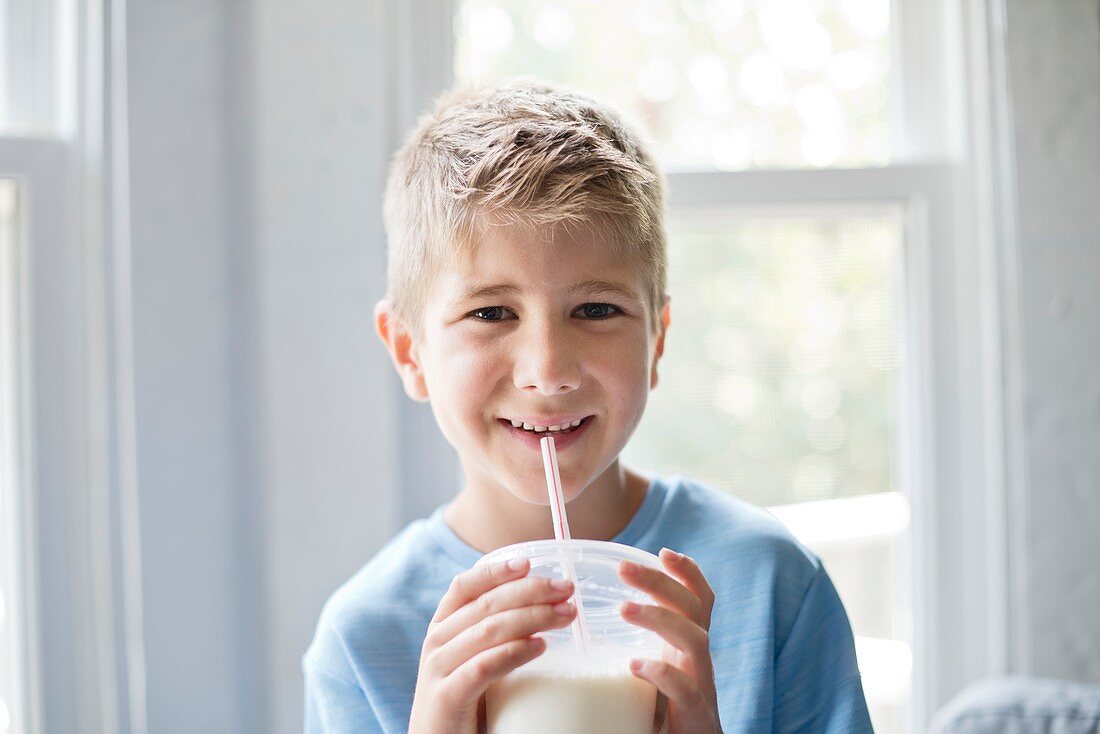 Boy drinking milk through a straw