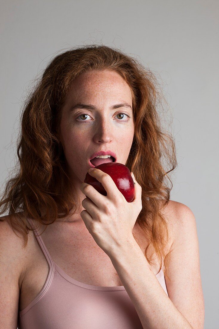 Portrait of woman eating red apple