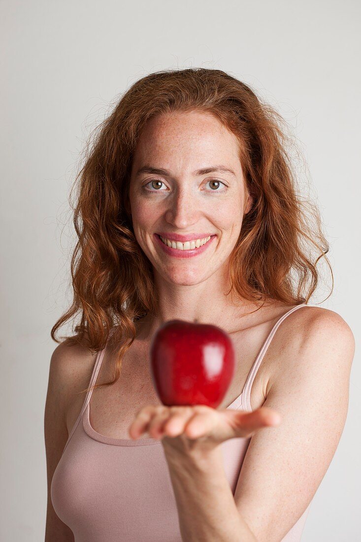 Portrait of smiling woman holding red apple