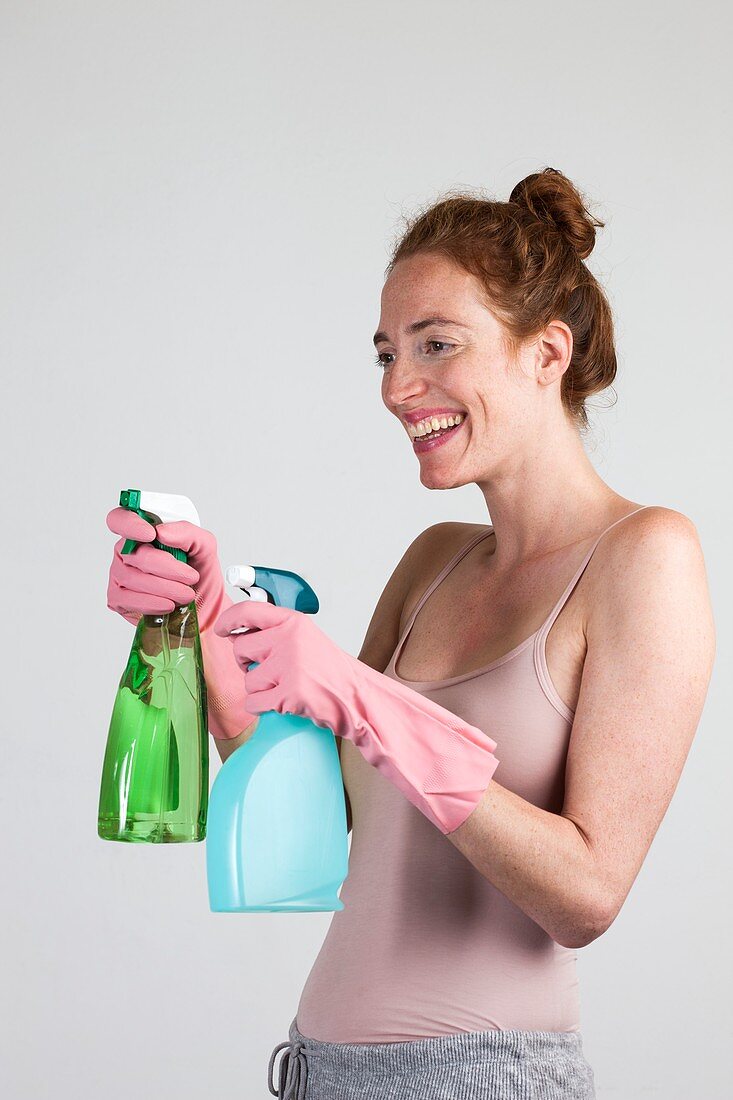 Woman with gloves holding cleaning materials