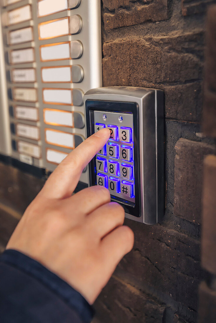 Woman entering passcode on security keypad
