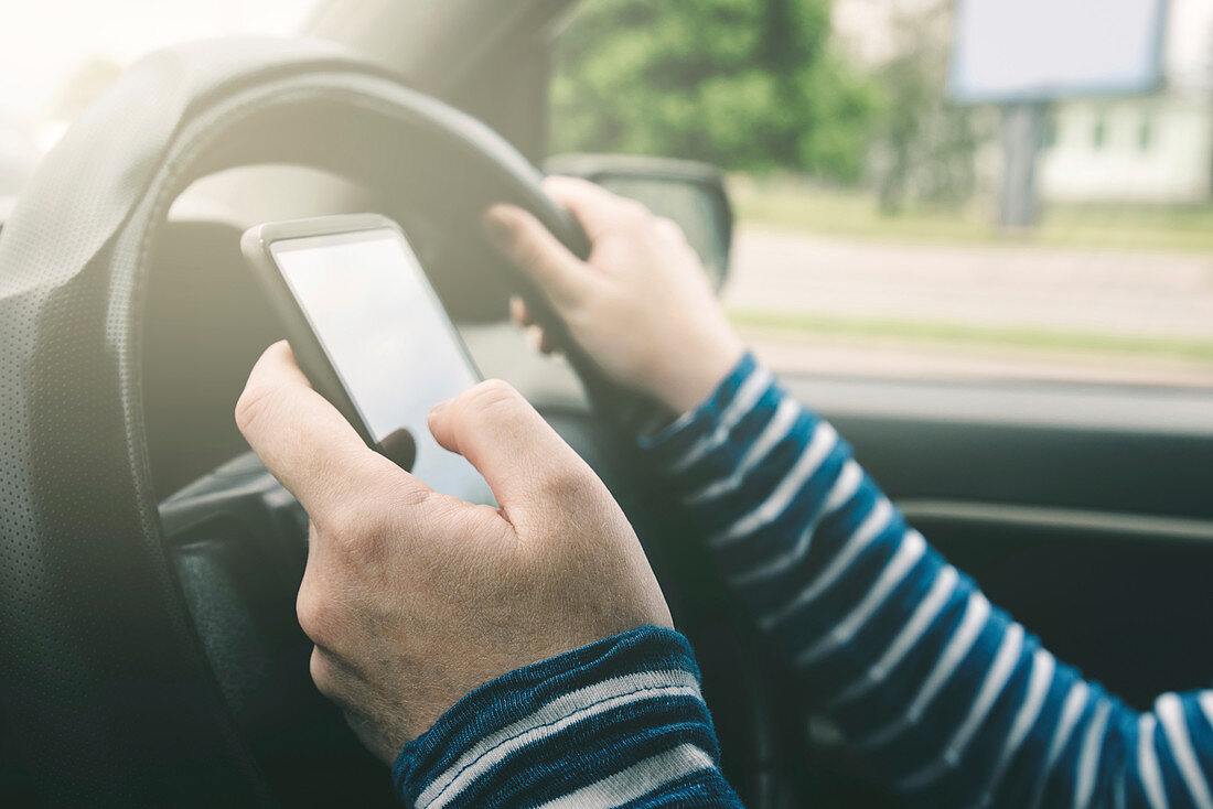 Woman driving car and using mobile phone