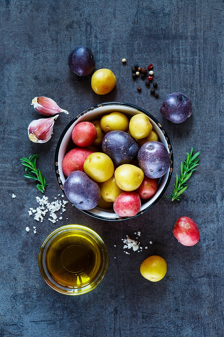 Stillleben mit bunten Kartoffeln, Knoblauch und Olivenöl