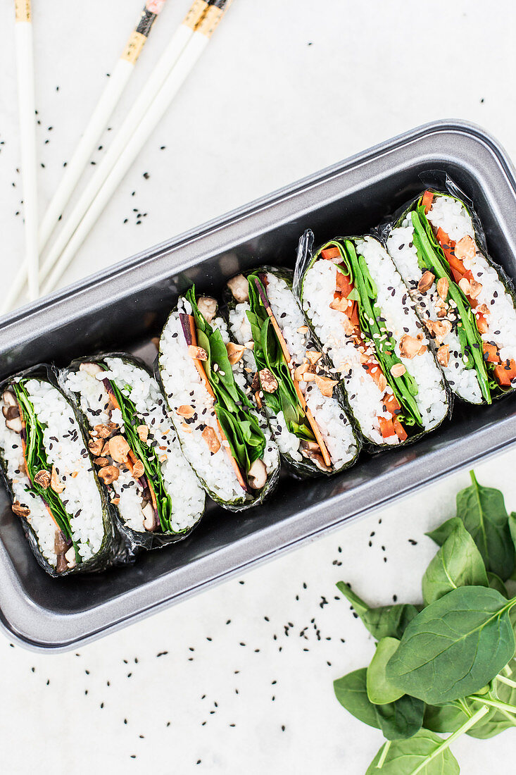 Sushi sandwiches with spinach, peppers, mange tout, black sesame seeds, colourful carrots, shiitake mushrooms and peanuts