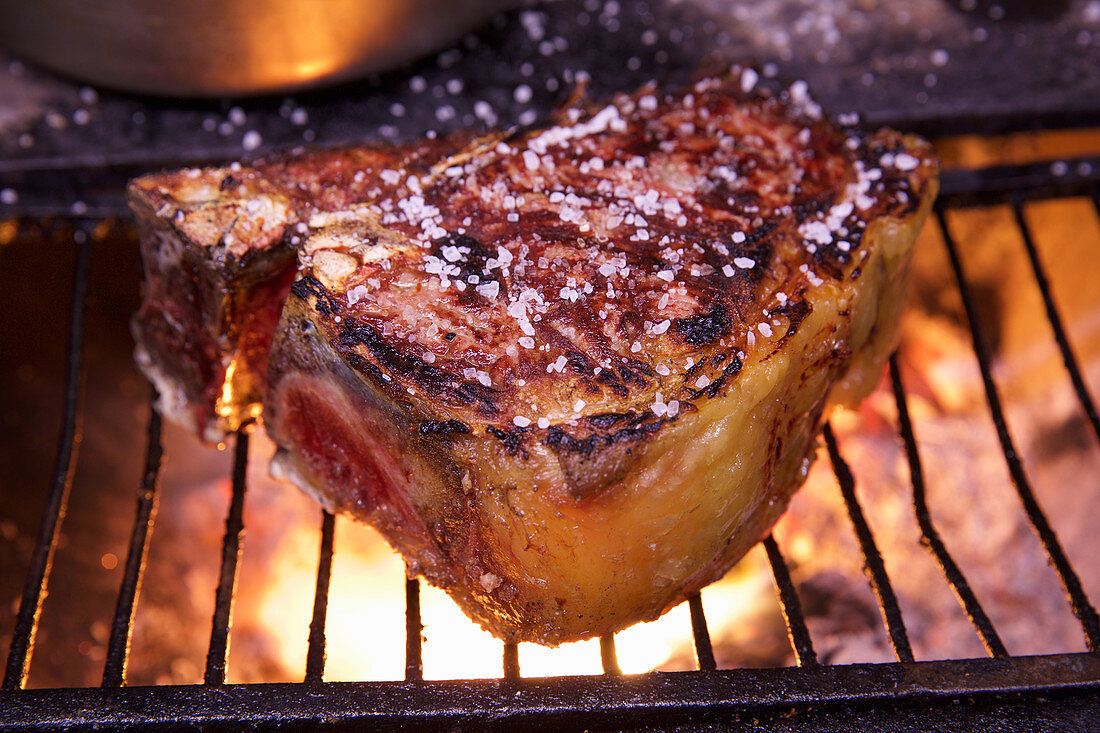 A salted steak on a grill