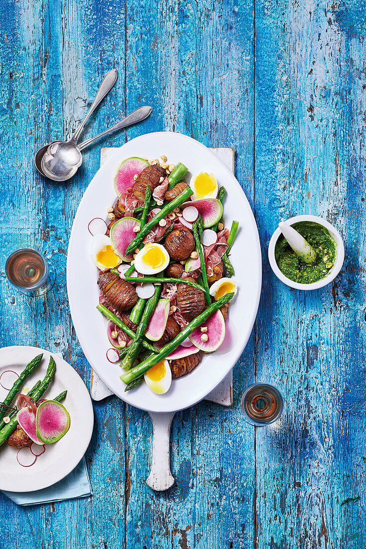 Spargelsalat mit Hasselback-Kartoffeln, Rettich, Eiern, Pesto und Haselnüssen