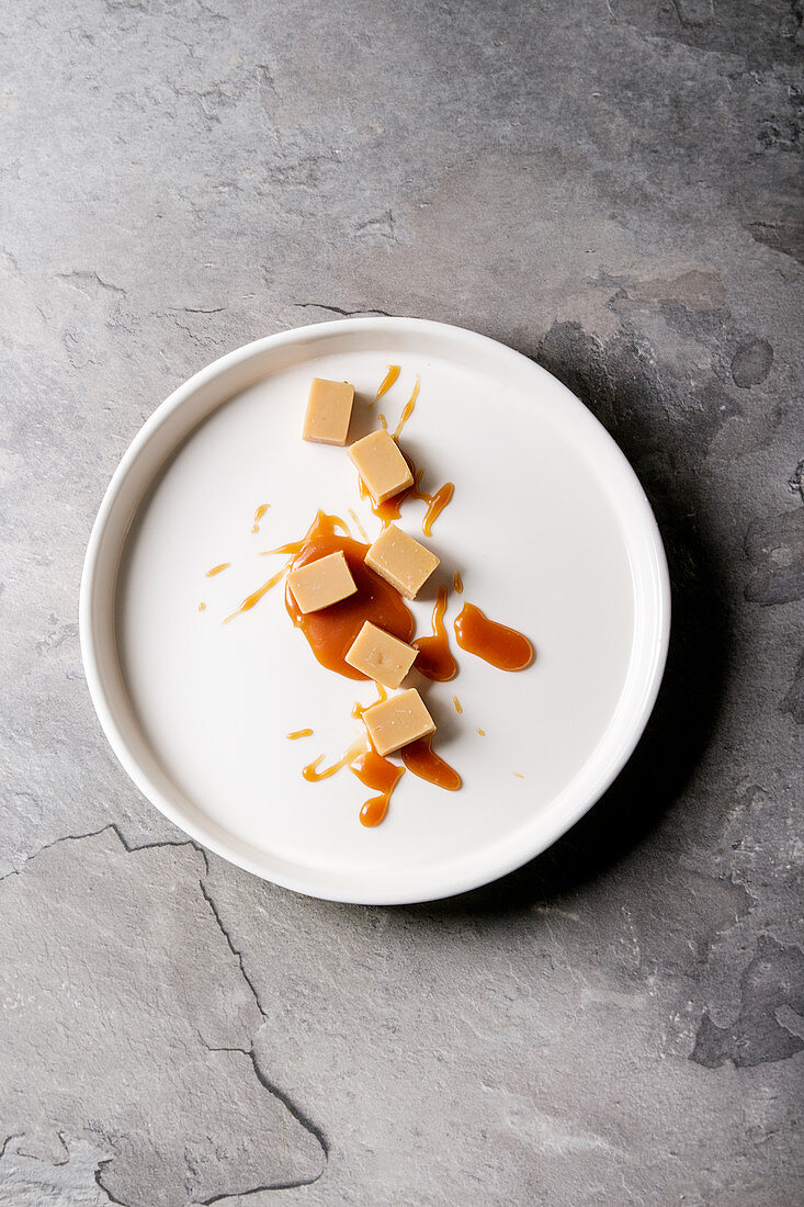 Salzkaramell-Fudge mit Karamellsoße auf weißem Teller