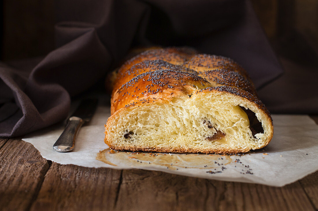 Sweet bread with poppyseeds, sliced on a piece of baking paper