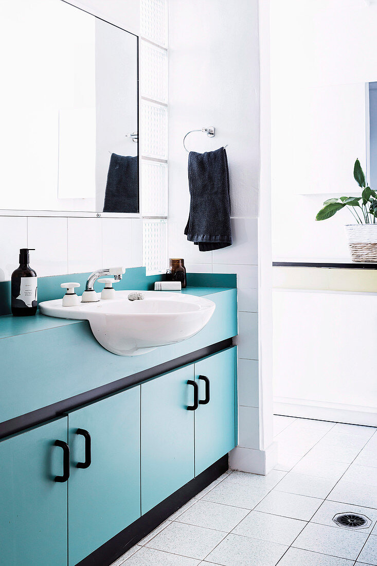 Weißes Badezimmer mit hellblauem Waschtischmöbel