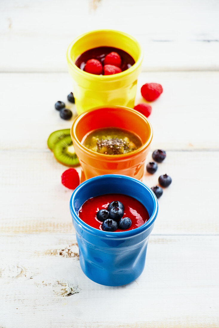 Bunte Smoothiegläser mit Beeren und Früchten