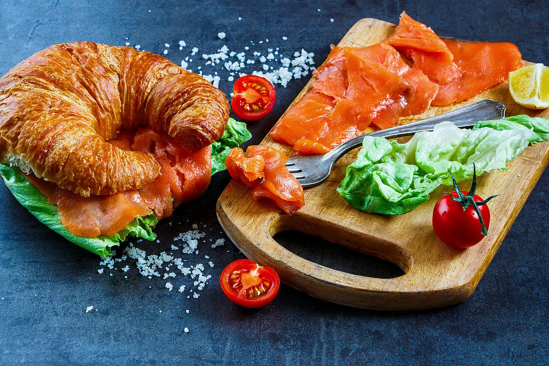 A croissant with smoked salmon and lettuce leaves