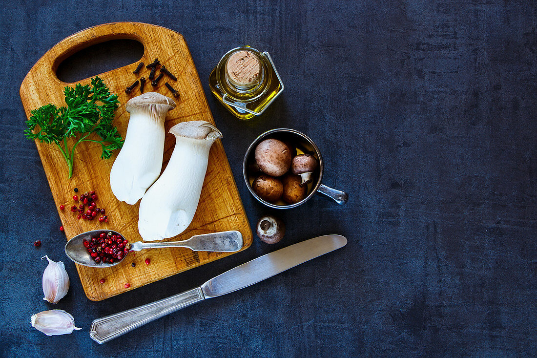 An arrangement of ingredients: mushrooms, herbs, spices and olive oil (seen from above)