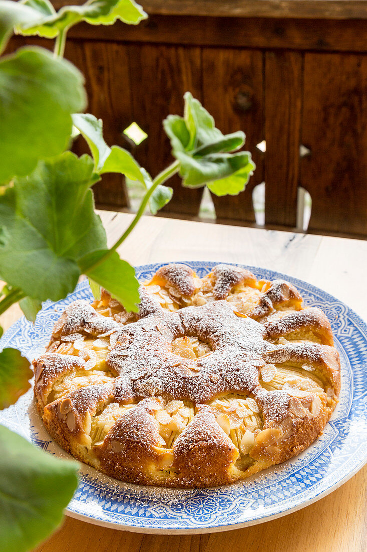 Apple cake with flaked almonds and icing sugar