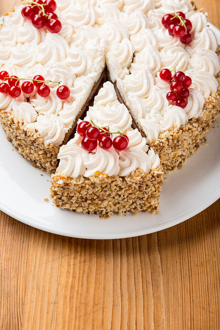 Nusstorte mit Sahne und roten Johannisbeeren