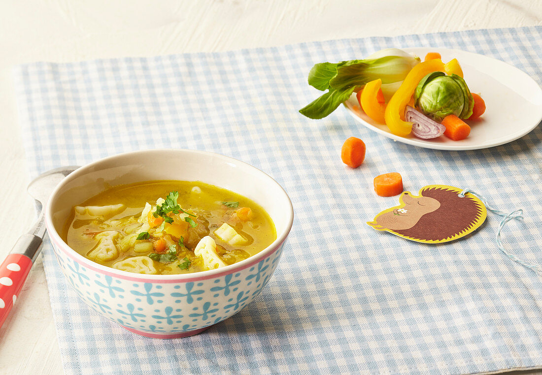 Vegetable soup with noodles in a little bowl with ingredients