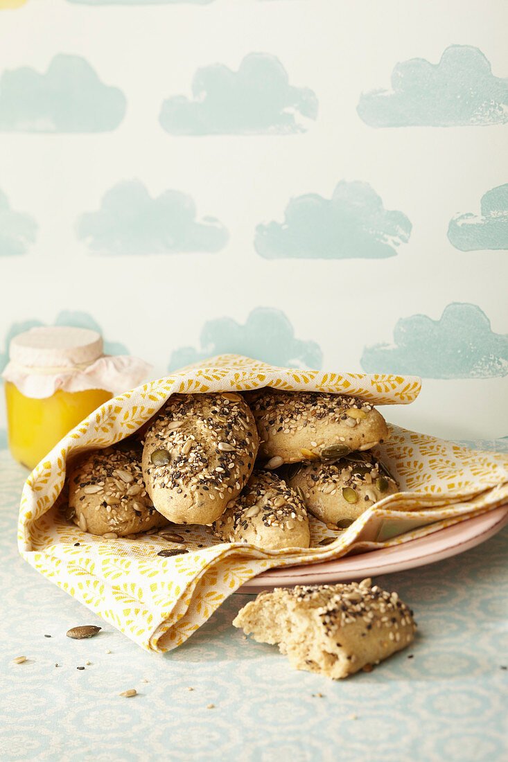 Homemade seeded rolls in a tea towel