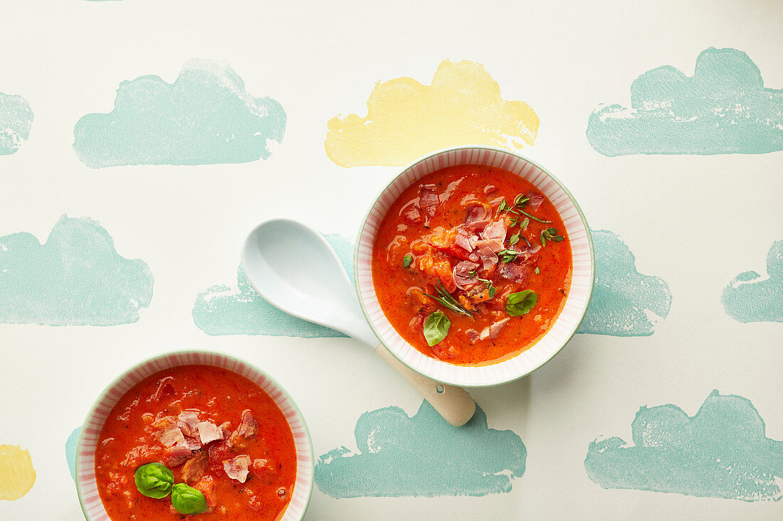 Two bowls of tomato soup with bacon