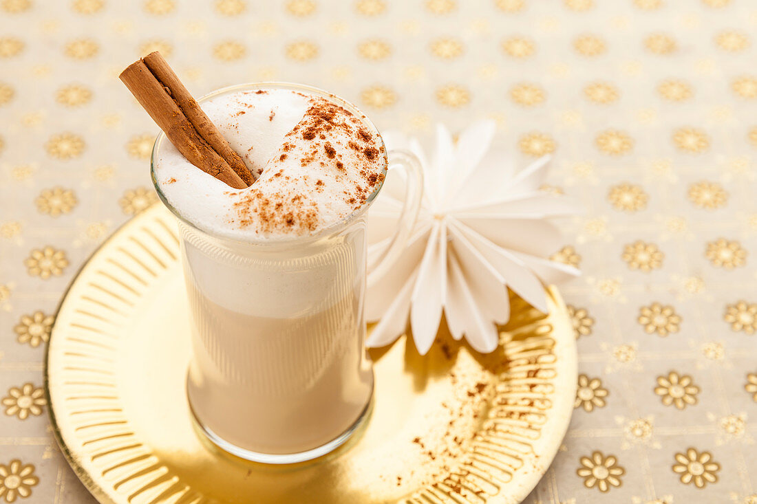 A wintery latte with milk foam and cinnamon in a glass cup