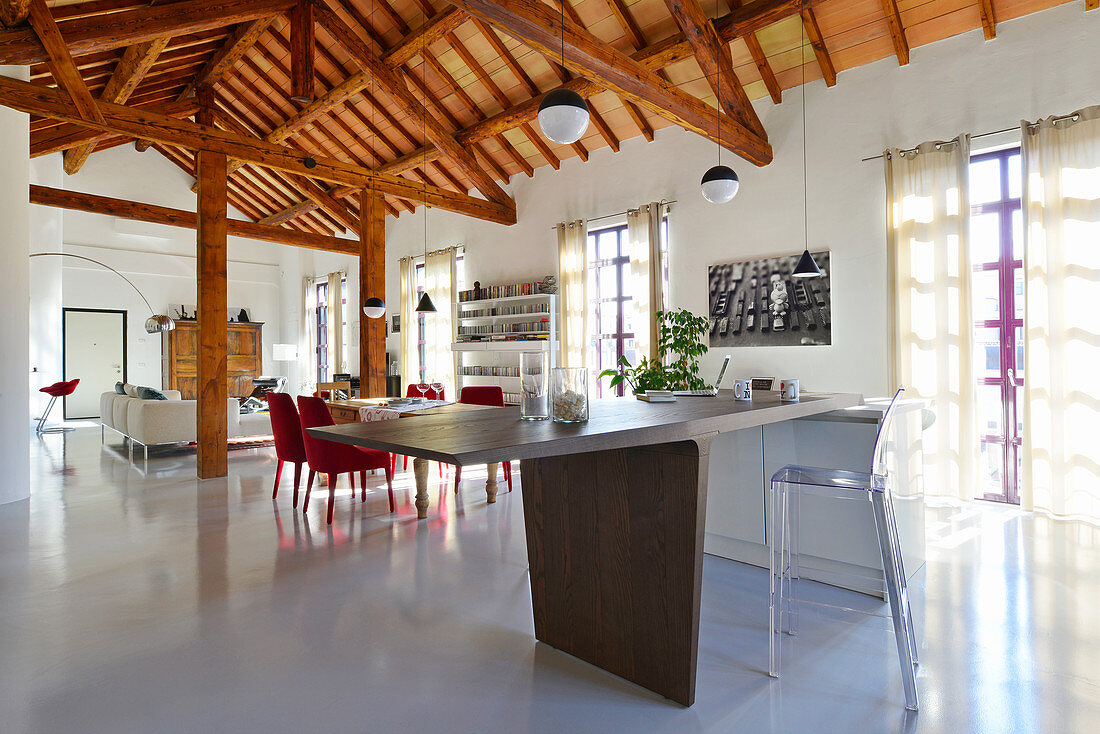 Modern open-plan interior with white floor and exposed roof structure