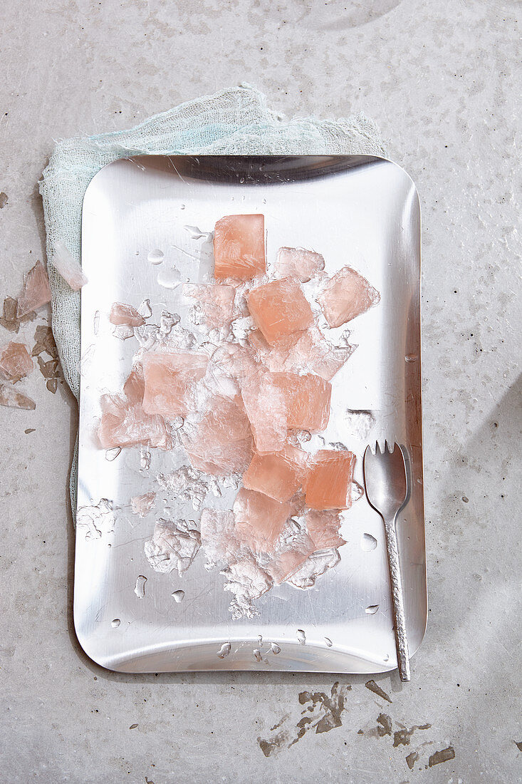 Rosé wine ice cubes and ice splinters on a silver tray